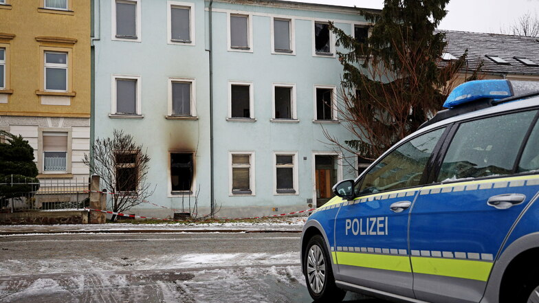Die Polizei bewachte am Dienstag das Haus an der Pausitzer Straße, in dem es während der vergangenen Tage mehrfach gebrannt hatte.