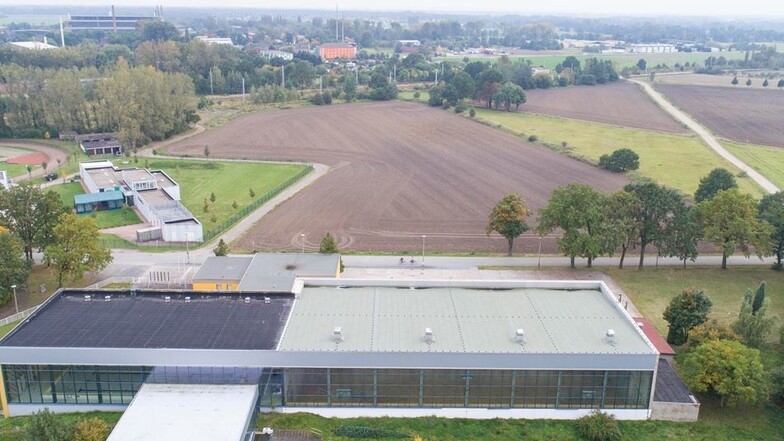 Die Schwimm- und Sporthalle Gröditz (Schwimmhalle mit dunklem Dach und Seitenanbau, Sporthalle rechts daneben)