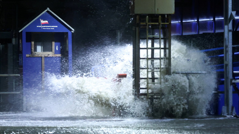 Der Gischt der aufgepeitschten Nordsee überflutet bei Sturm den Fähranleger Dagebüll.