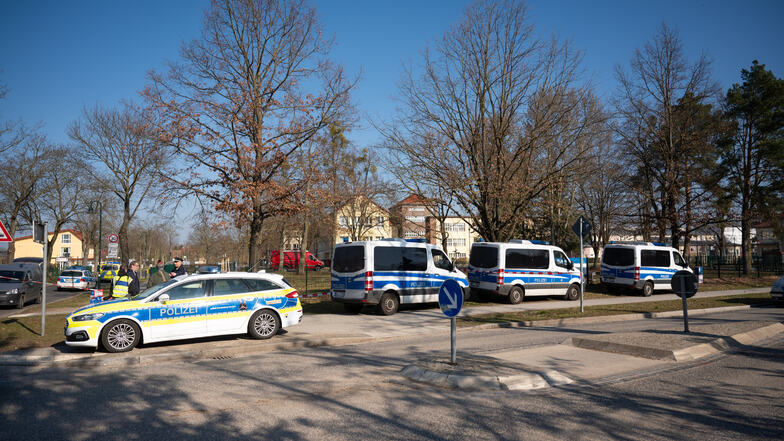 Polizeiautos stehen vor einer Schule. In der Schule wurde ein 22 Jahre alter Mann festgenommen, der ein Messer und eine Schusswaffe bei sich gehabt hat. Der Mann wurde festgenommen.