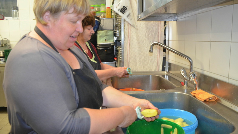 Mandy Plumrich (vorn) und Heike Schwerdtner schälen Kartoffeln im Akkord per Hand.