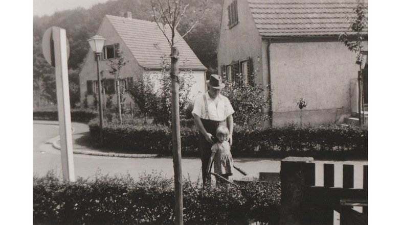 Eva mit Vater Karl auf der Straße vor dem Haus der Familie um 1938. Hinter dem Gebäude links wurde später der Luftschutzstollen in den Berg getrieben.