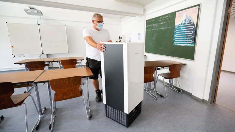Ein Luftfilter wird in einen Klassenraum einer Schule geschoben. Die Bundesmittel dafür sind nur wenig genutzt worden.