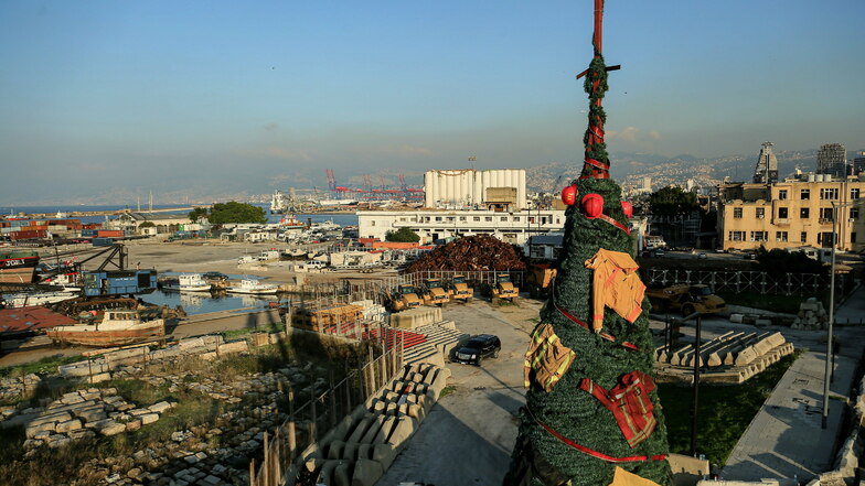 Ein mit Kleidung und Ausrüstung von Ersthelfern und Feuerwehrleuten geschmückter Weihnachtsbaum steht am Eingang des zerstörten Beiruter Hafens. Der Weihnachtsbaum wurde zu Ehren der Feuerwehrleute aufgestellt, die am 04. August 2020 bei der Explosion im 