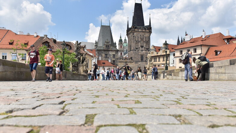 Touristen sind auf der Karlsbrücke in Prag unterwegs.