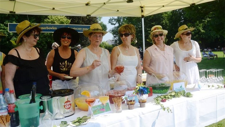 Gut beschirmt sind die lustigen Damen, die an ihrem Stand im Muskauer Fürst-Pückler-Park alkoholfreie Bowle verkaufen.