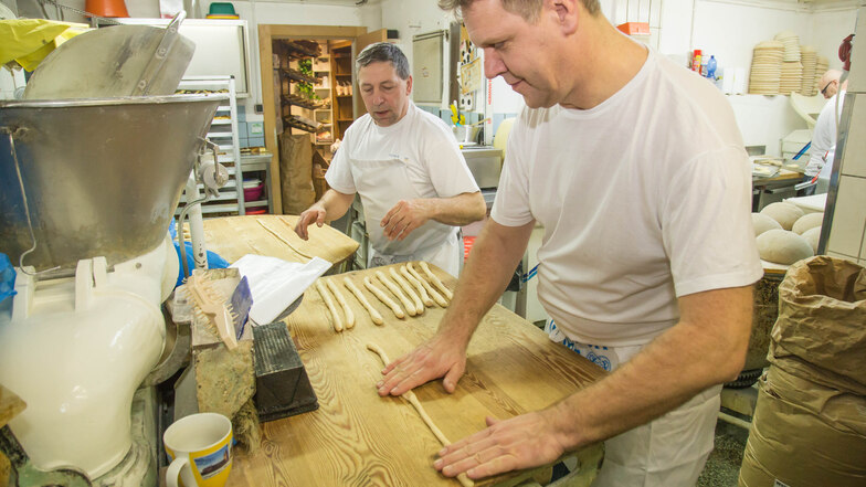 Bäckermeister Uwe Kopke erklärt SZ-Redakteur Steffen Gerhardt, wie aus diesen Teigrollen Brezeln gemacht werden.