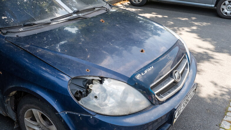 Ukrainisches Auto mit Einschusslöchern, geparkt auf dem Parkplatz der Straßenbahnendhaltestelle in Weinhübel. Auf der Windschutzscheibe wurde ein Aufkleber des Ordnungsamtes angebracht.
