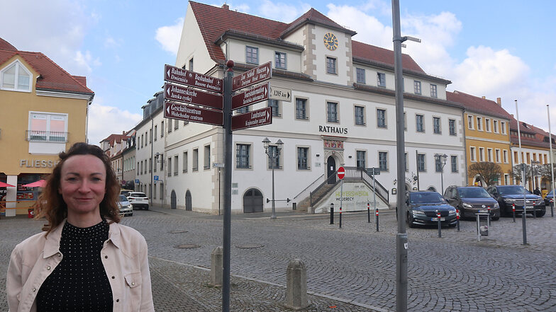 Diana Karbe (42) steht vor dem zweisprachigen Wegweiser-Schild am Hoyerswerdaer Marktplatz gegenüber dem Alten Rathaus. Seit Anfang 2022 ist sie Projektmanagerin der Stadt Hoyerswerda mit Spezialisierung Wirtschaftsförderung.