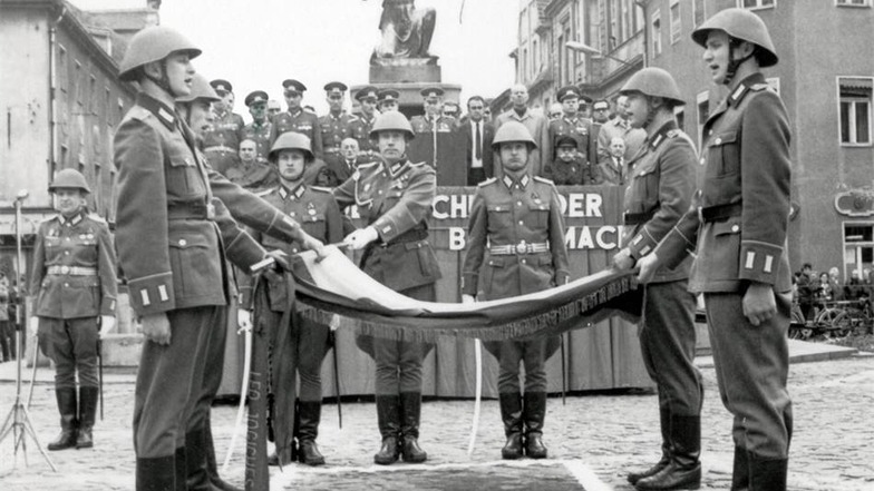 Vereidigung mit Panzer Der Großenhainer Brunnen war auch in der DDR-Kulisse für Machtdemonstration. Am 12. Mai 1972 fand eine öffentliche Vereidigung von neu einberufenen Soldaten des 16. Panzerregiments Leo Jogiches auf dem damaligen Karl-Marx-Platz statt. Die Waffen erhielten sie nach dem Schwur von Arbeitern aus der Kampfgruppe des Fortschrittskombinates. Hunderte Werktätige, Jugendliche und Pioniere wurden zu der Veranstaltung hinzuzitiert – es war ein Sonntag. Auf der Tribüne sitzen auch die Parteiveteranen: auf der rechten Seite mit weißem Schnauzbart Paul Schäfer und rechts daneben Richard Zöllner, Wilhelm Senftleben, Alfred Großmann und Paul Heinze. Außerdem Karl-Heinz Jäschke, damaliger Sekretär der SED-Kreisleitung. Die Ansprache hielt Gerhard Schwarzwalder, Parteisekretär im VEB Fortschrittkombinat. Auch ein Panzer war vor den Dianabrunnen gefahren.