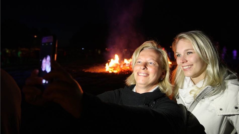 Andrea (36) aus Heidenau und Jenny (27) aus Dresden,  die beiden machen mit ihrem Smartphone ein Selfie vor dem wärmenden Walpurgisfeuer in Heidenau