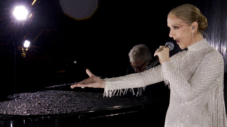 Celine Dion singt bei der Eröffnungsfeier auf dem Eiffelturm unter den olympischen Ringen.