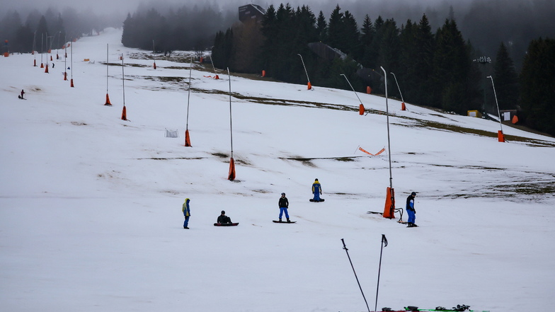 Nur vereinzelte Wintersportler fahren am Donnerstag bei Regen und Plusgraden auf dem Skihang am Fichtelberg.
