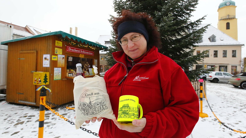 Die Glühweinbude auf dem Markt in Pulsnitz ist geöffnet. Ria Schirrmeister zeigt, was es unter anderem zu kaufen gibt.