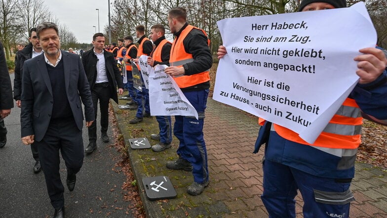Robert Habeck (l. Bündnis 90/Die Grünen), Bundesminister für Wirtschaft und Klimaschutz geht bei einem Besuch vom Braunkohlekraftwerk Schwarze Pumpe der LEAG an protestierenden Lehrlingen und Mitarbeitern vorbei.