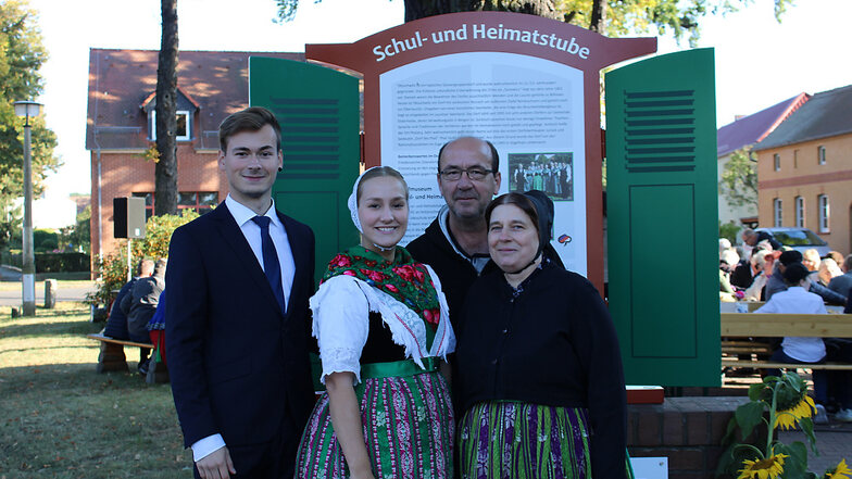 Familie Petzer aus Tätzschwitz vor der enthüllten Info-Tafel. Die Familie beteiligte sich anlässlich des 20-jährigen Bestehens der Schul- und Heimatstube am Trachtenumzug und unterstützt auch sonst die Aktivitäten dieser Einrichtung.
