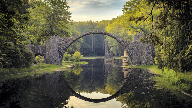 Die Rakotzbrücke im Kromlauer Park ist durch Material, Bauform und Spiegelung im Rakotzsee als Rundbogenbrücke längst kein Geheimtipp mehr für Touristen und Fotografen, sondern weltberühmt. Künftig soll auf dem Rakotzsee und unter der Brücke sogar