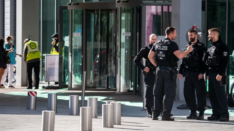 Polizisten und Sicherheitsmitarbeiter stehen vor dem Haupteingang der Berliner Charité.