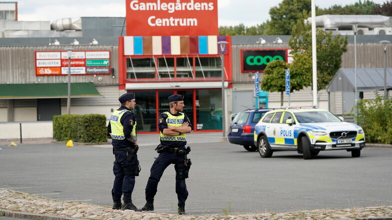 Zwei Polizisten stehen nach Schüssen in Kristianstad an einem Tatort.