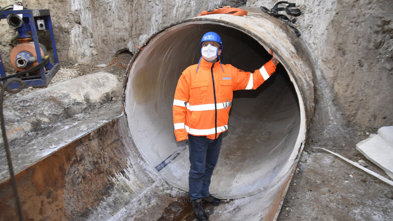 Ralf Strothteicher steht im bereits abgedichteten Altstädter Anschluss des Abwassertunnels. Hinter dem Chef der Stadtentwässerung ist der neue, ausgehärtete Schlauch an der Wand der zwei Meter hohen Röhre gut zu sehen.