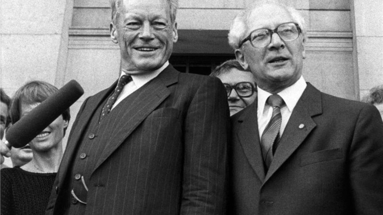 Während seines Besuchs in der DDR traf der SPD Vorsitzende Willy Brandt (l, SPD) am 19. September 1985 in Ost-Berlin mit dem DDR-Staatsrat- und Parteivorsitzenden Erich Honecker zusammen. Hier während eines Stadtbummels vor dem Deutschen Schauspielhaus.