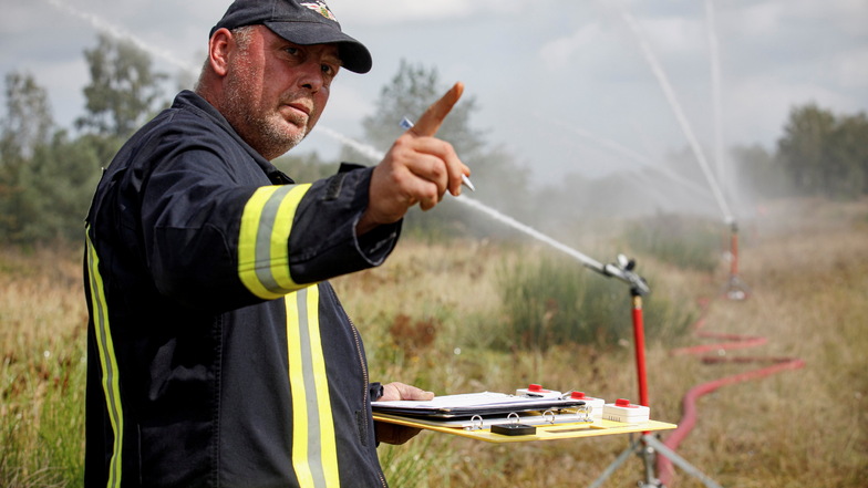 Ein Feuerwehrmann notiert den Wasserverbrauch bei der Übung in der Gohrischheide. In dem munitionsverseuchten Gelände gilt eigentlich Löschverbot.