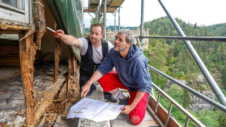 Kaum noch etwas übrig: Bauplaner Steffen Herrmann (vorn) und Zimmerer Robert Scholz besehen sich die schlimmen Schäden an der Nordwand des Oybiner Berggasthofs. Die wird jetzt notgesichert.