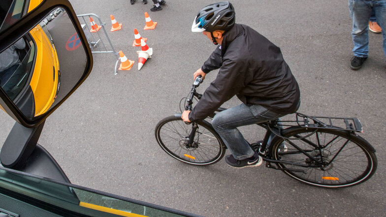 Ein Fahrradfahrer fährt während einer Demonstration des neuen Abbiegeassistenten neben einem Lastwagen.
