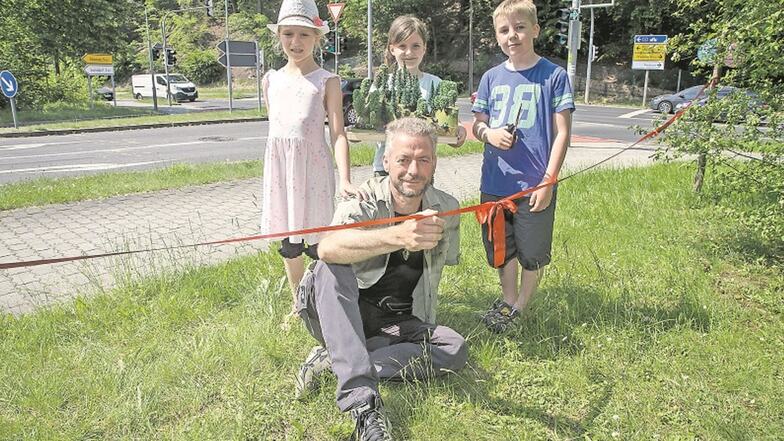Die Schüler der Grundschule Hainsberg Melina, Alika und Jonas (v.l.) eröffnen mit Wildnistrainer Jörg Ulbricht das neue Tierspurenrätsel in Hainsberg.