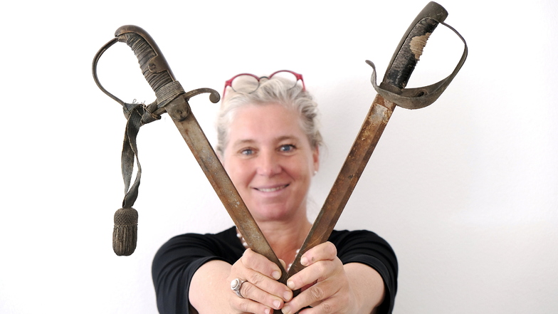 Die Geschäftsführerin des Meißner Theaters Ann-Kristin Böhme zeigt die beiden Schwerter, die auf dem Dachboden gefunden wurden.