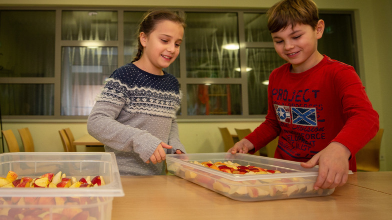 Anna und Noah der Klasse 3b nehmen ein Tablett mit Obst von der Schulküche mit in den Klassenraum. Schüler der Grundschule Graupa bei Pirna bekommen Obst- und Gemüse geliefert. Kostenlos.