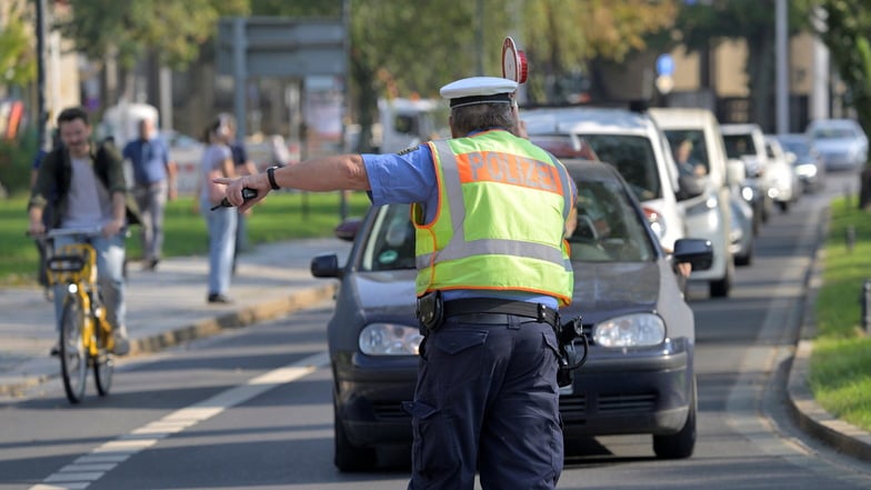 Polizeihauptmeister Thomas Hentsch winkt am Donnerstag auf dem Güntzplatz in Dresden ein Auto heraus.