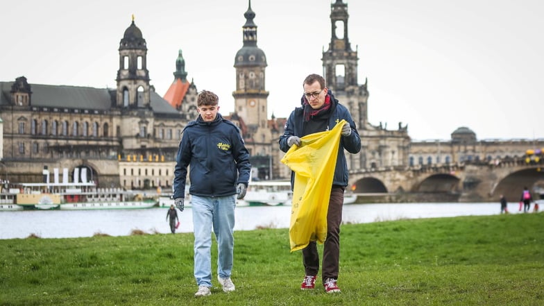 Julian Pratsch (l.) und Roman Sorge sammeln Müll auf den Dresden Elbwiesen ein.