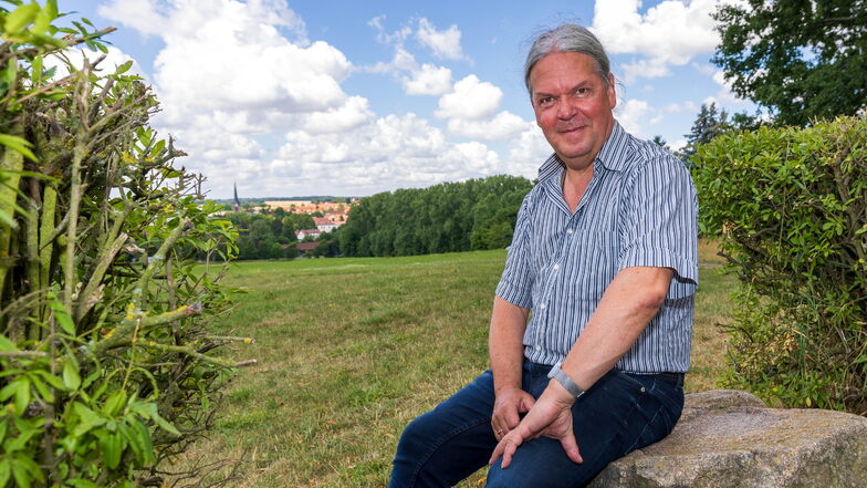 Matthias Schlönvogt sitzt auf Stein auf der Anhöhe Hühndorfer Höhe. Die Fläche unterhalb soll demnächst umgestaltet werden. Hier könnte auch ein Stadtpark entstehen.