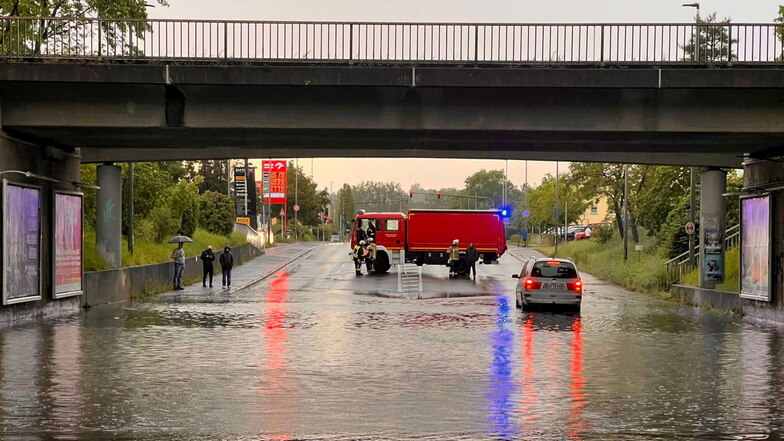 Ein Einsatzfahrzeug der Feuerwehr sichert am Donnerstag im bayerischen Bamberg eine mit Regenwasser vollgelaufene Unterführung ab.