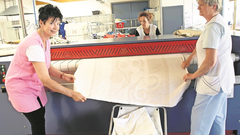 Die Hauswirtschafterinnen Petra Rapp und Ilona Pasterny sowie Corina Müller, Gruppenleiterin der Wäscherei (v.l.n.r.), arbeiten in der Wäscherei der Lebenshilfe-Werkstätten. Normalerweise sind hier 24 Beschäftigte tätig, durch Corona sind es nur sechs.