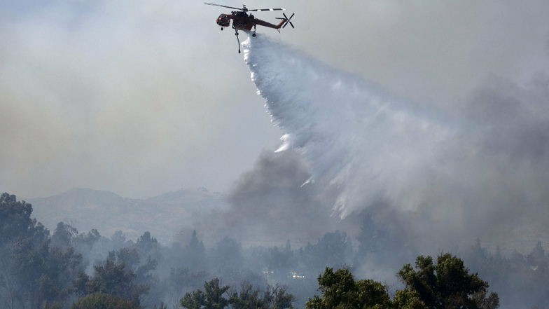 Ein Feuerwehrhubschrauber ist bei einem Waldbrand im Einsatz.