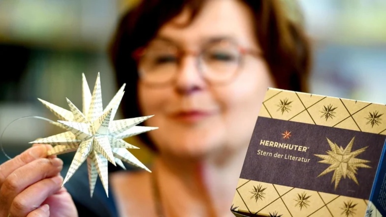 Heike Csoti von der Herrnhuter Comenius-Buchhandlung hält einen "Stern der Literatur" in den Händen. Er ist zum 125. Jubiläum der Buchhandlung aufgelegt worden.
