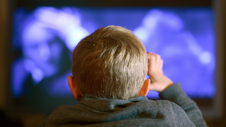 Ein Junge sitzt vor dem Fernseher statt im Unterricht.