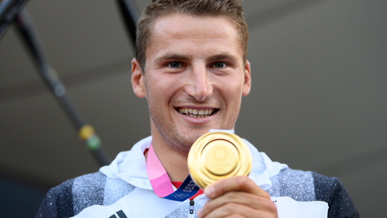 Stolz hält Tom Liebscher die olympische Goldmedaille in die Kamera. Es ist bereits seine zweite.