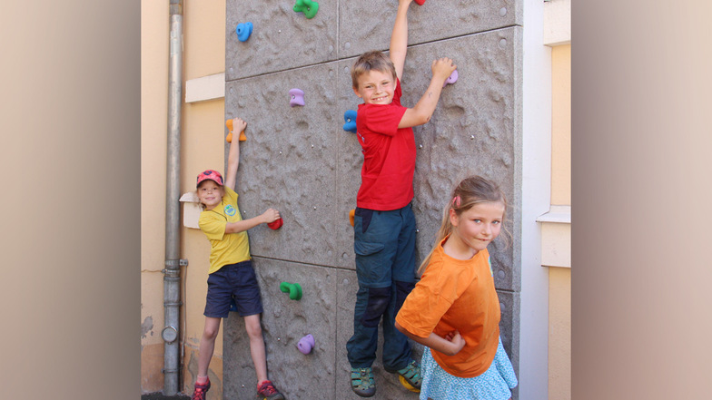 An der Grundschule in Demitz-Thumitz gibt es jetzt eine Kletterwand. Pia, Johann und Matilda (v.l.) haben sie zuerst ausprobiert.