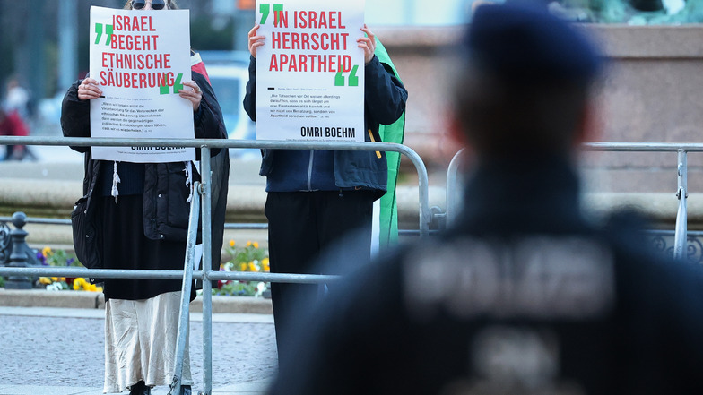 Zwei Personen demonstrieren mit anti-israelischen Plakaten vor der Eröffnung der Leipziger Buchmesse vor dem Gewandhaus.