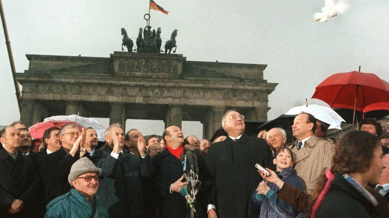 Hans Modrow (3.v.l., klatschend), damals DDR-Ministerpräsident, und Helmut Kohl (CDU), damals Bundeskanzler, lassen vor dem Brandenburger Tor Friedenstauben aufsteigen.