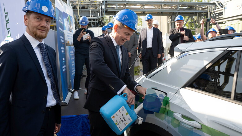 Verkehrsminister Volker Wissing (FDP) und Ministerpräsident Michael Kretschmer (CDU), betanken vor der Großversuchsanlage für E-Fuels der TU Bergakademie Freiberg ein Fahrzeug mit dem synthetischen Kraftstoff.