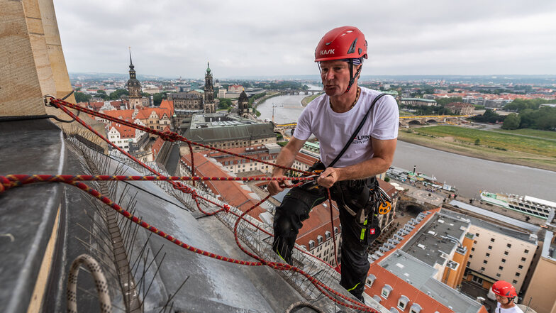 Höhenarbeiter Andreas Rösler seilt sich am Dienstag an der Kuppel der Frauenkirche hinab.