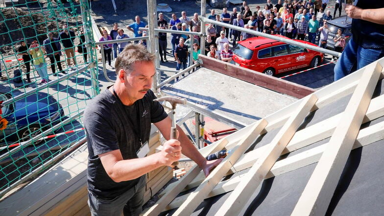 Bauherr und Investor André Zarse schlägt den letzten Nagel in den Dachstuhl ein. Jetzt kann Richtfest für die ersten Häuser der neuen Wohnsiedlung Brunnenweg im Kamenzer Ortsteil Cunnersdorf gefeiert werden.