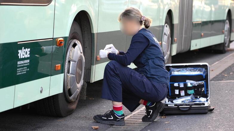 Eine Beamtin der Kriminalpolizei sichert vor Ort Spuren am Bus. DVB und RVSOE fahren gemeinsam auf der Linie 66 die Dresden und Freital verbindet.