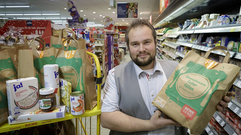Benjamin Geschwill, Leiter des Görlitzer Rewe-Marktes, mit einer gepackten Tüte der Aktion „Gemeinsam Teller füllen“.