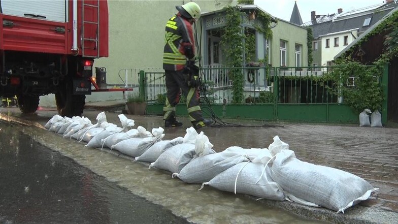 Mit Sandsäcken versuchen Feuerwehrleute, die Fluten einzudämmen.