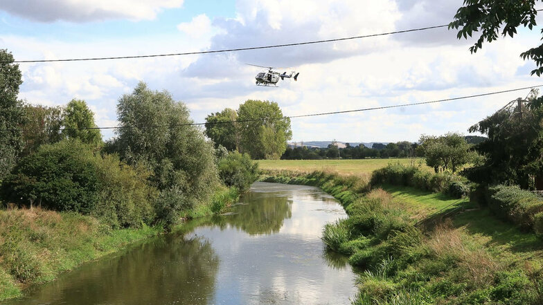 Ein Helikopter überfliegt die Unstrut. Feuerwehrleute suchen seit Sonntagmittag am Flussufer bei Schönewerda (Kyffhäuserkreis) nach einem Krokodil, das eine Pferdebesitzerin gesichtet haben will. Der Landkreis sprach eine öffentliche Warnung aus.